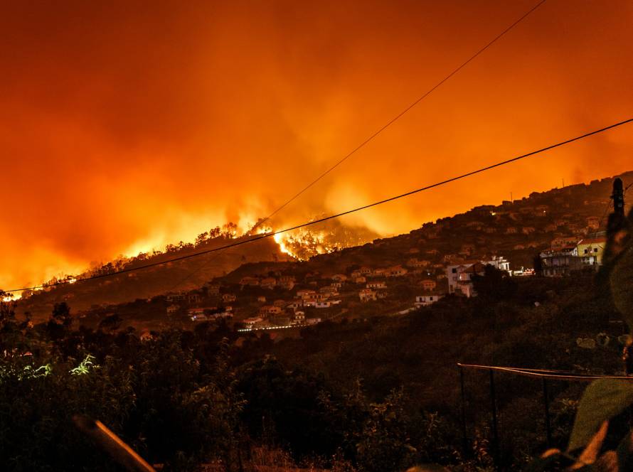 Wildfire at night burning hillside near homes