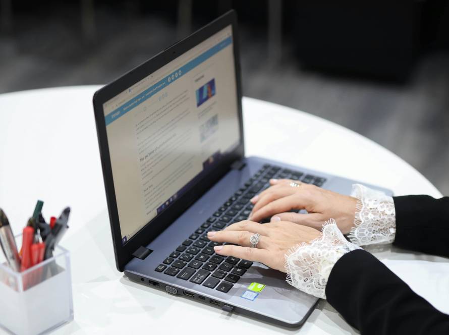 Hands with lace cuffs typing on laptop