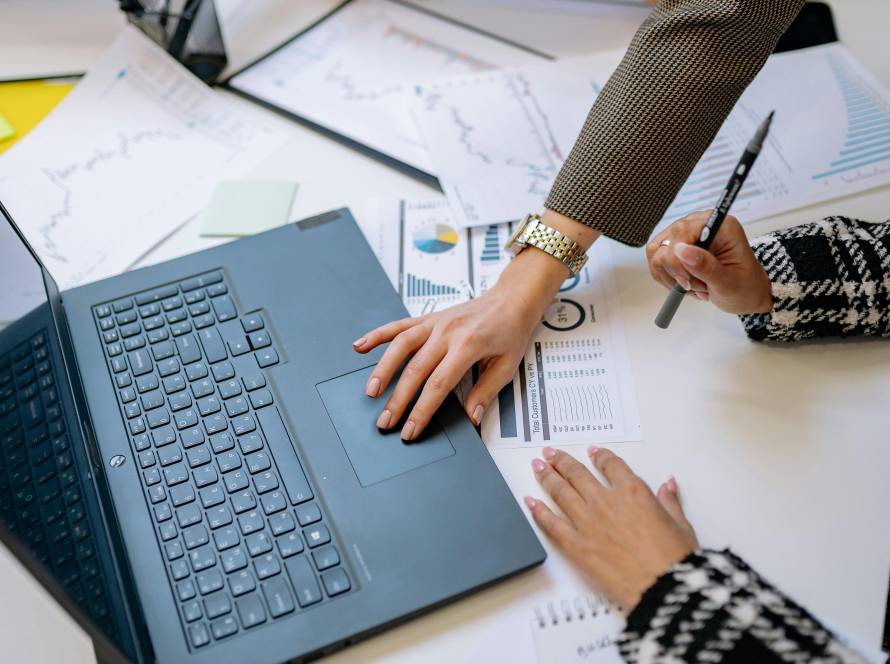 Business team reviewing charts beside open laptop