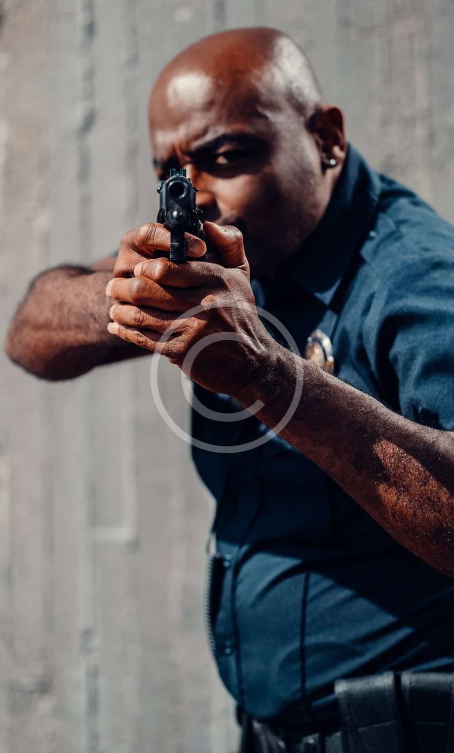 Police officer aiming handgun at camera