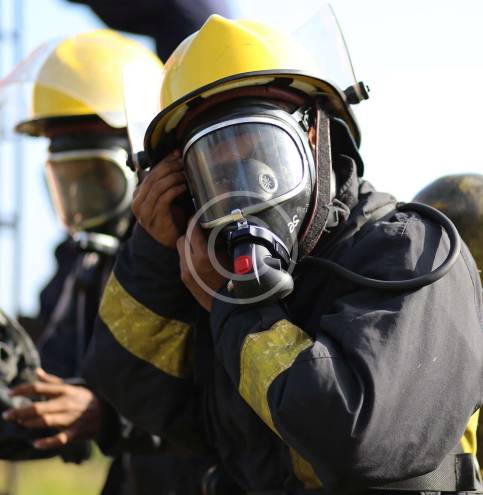 Firefighter wearing gas mask and yellow helmet